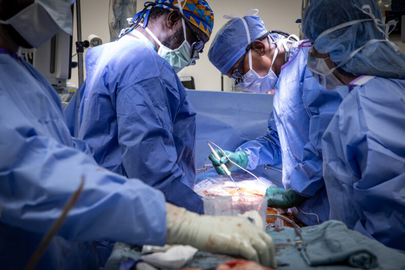 Close up photo of doctors in blue scrubs performing surgery