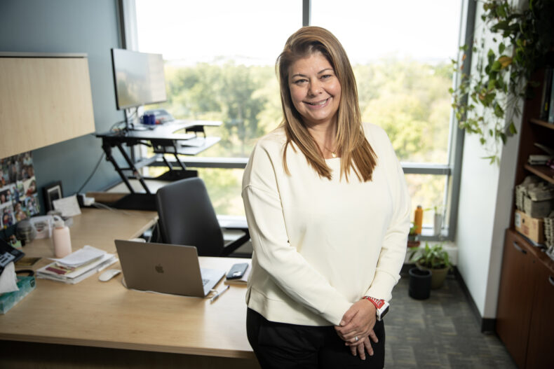 Dr. Jennifer (Piper) Below poses for a photo in her office