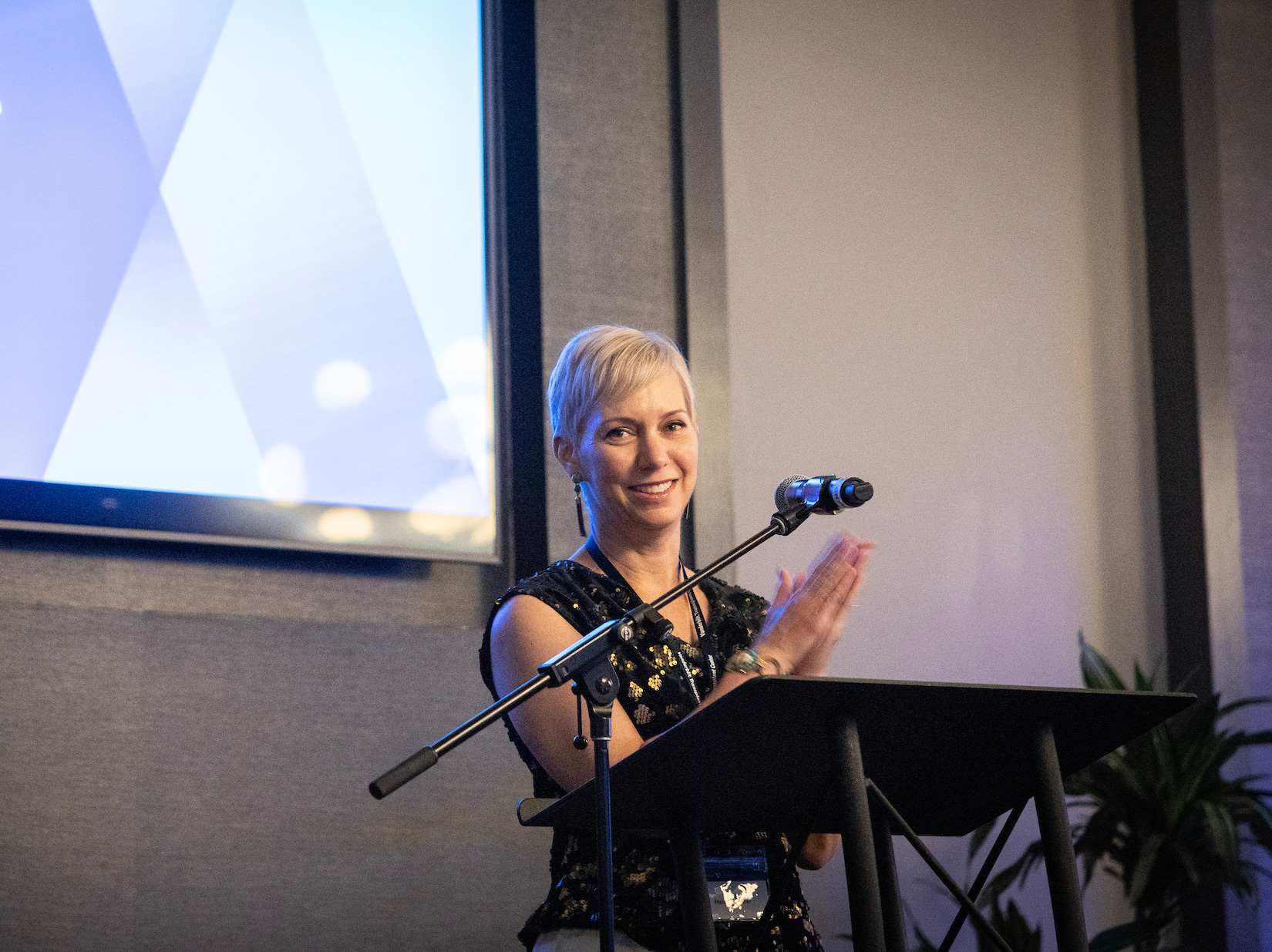Dr. Heidi Schaefter applauds at the podium