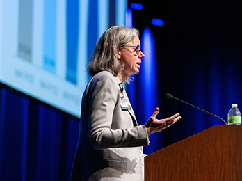 Dr. Anna Hemnes speaks at a podium during a presentation.