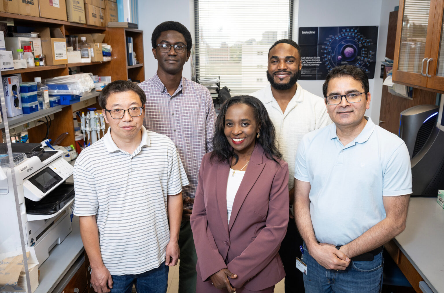 Five members of the Kirabo Lab, four men and one woman, pose for a photo