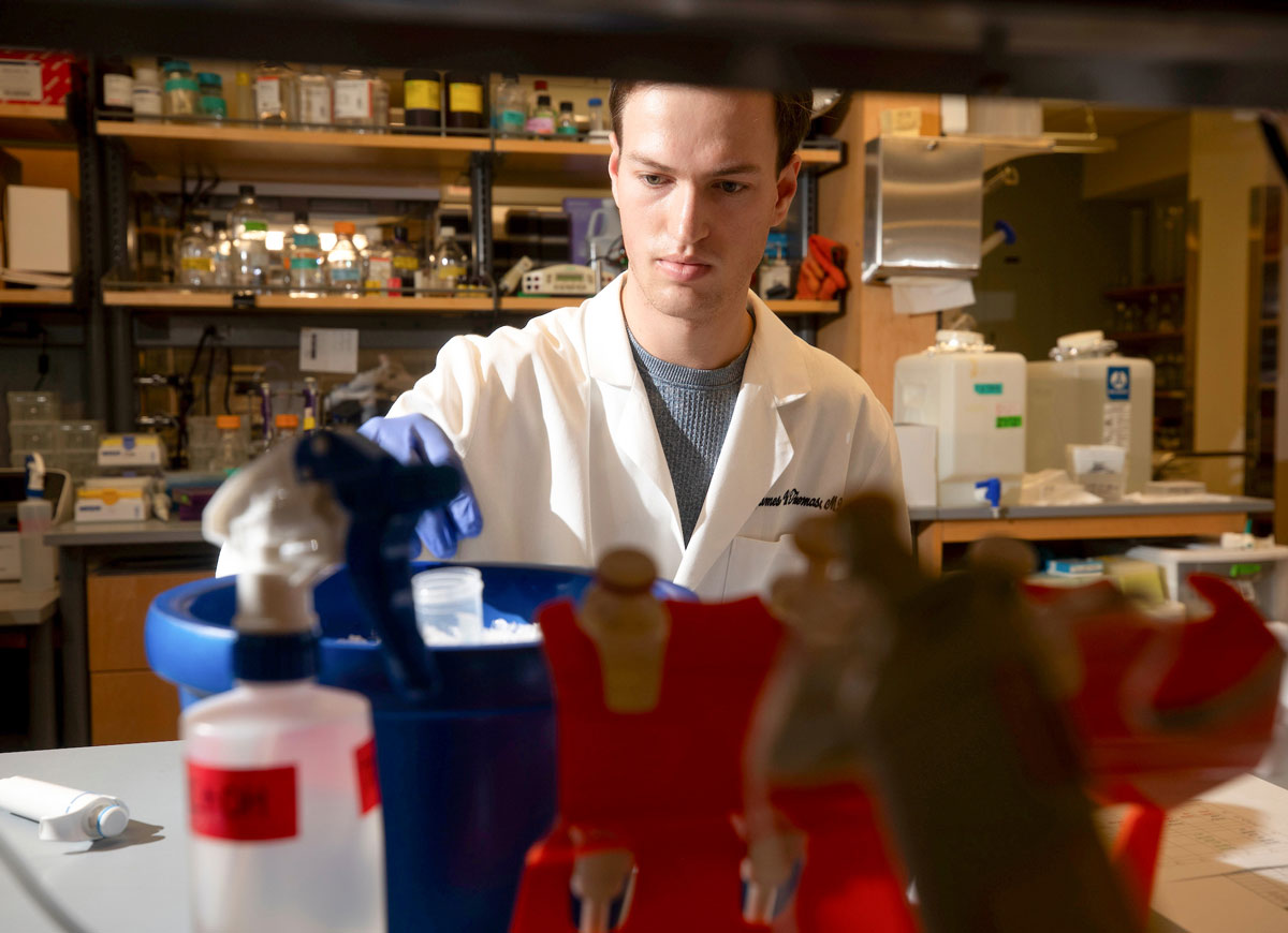 A young male researcher works in the lab.
