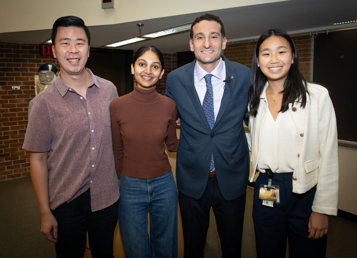 Fellowship director poses with 3 medical students in a lecture hall.