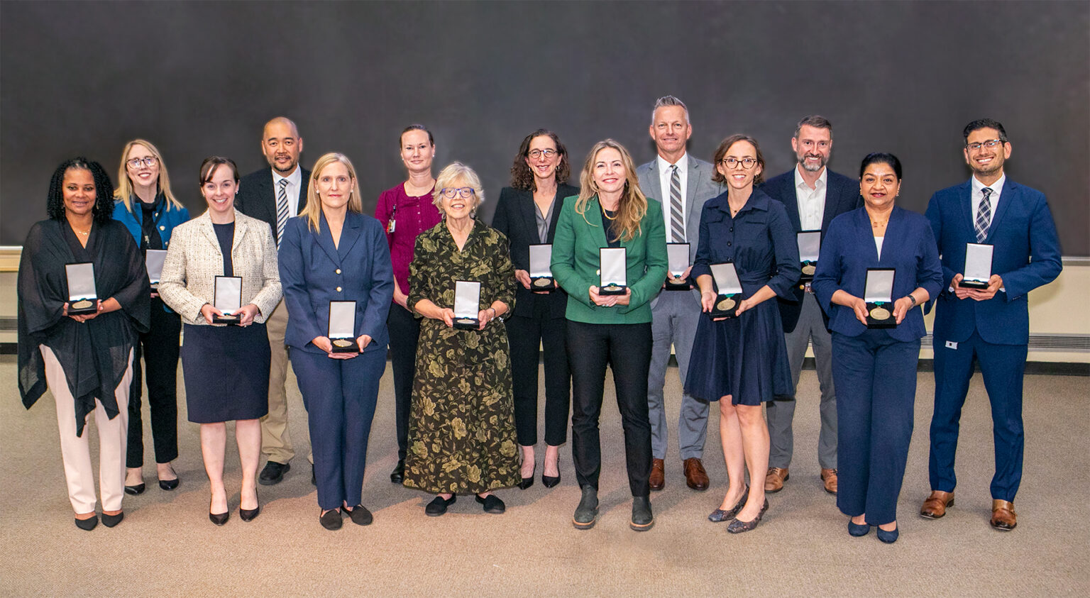 Fourteen of the new Vanderbilt Health directorship holders pose with a recognition of their award.