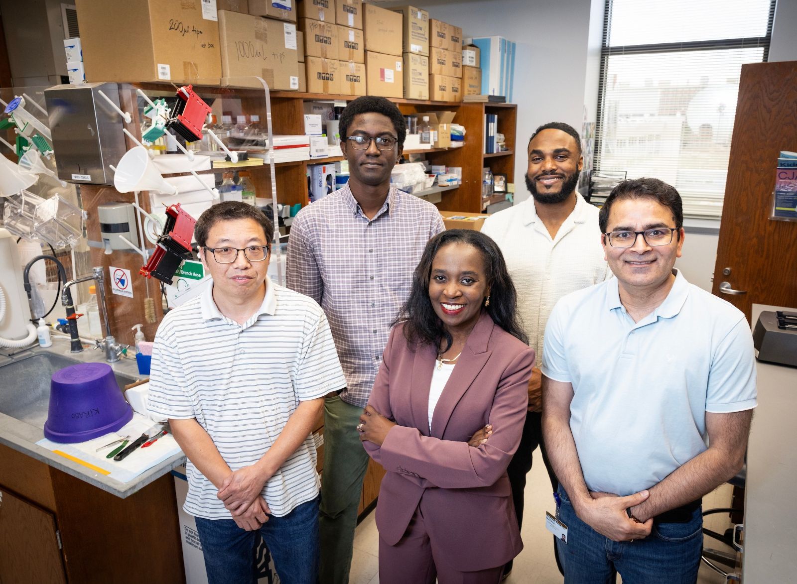 Five members of the Dr. Annet Kirabo research group pose in the lab.