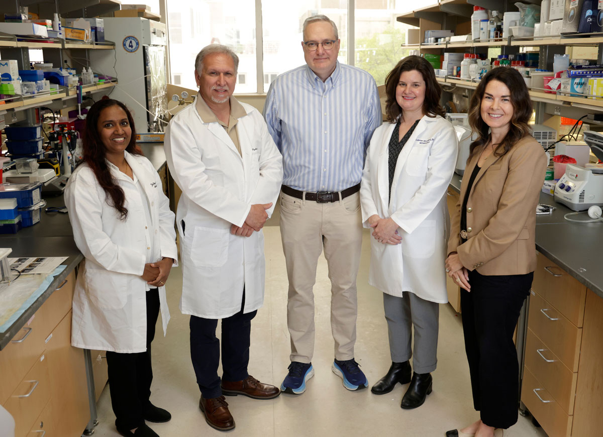 Two male and three female researchers pose in their lab.