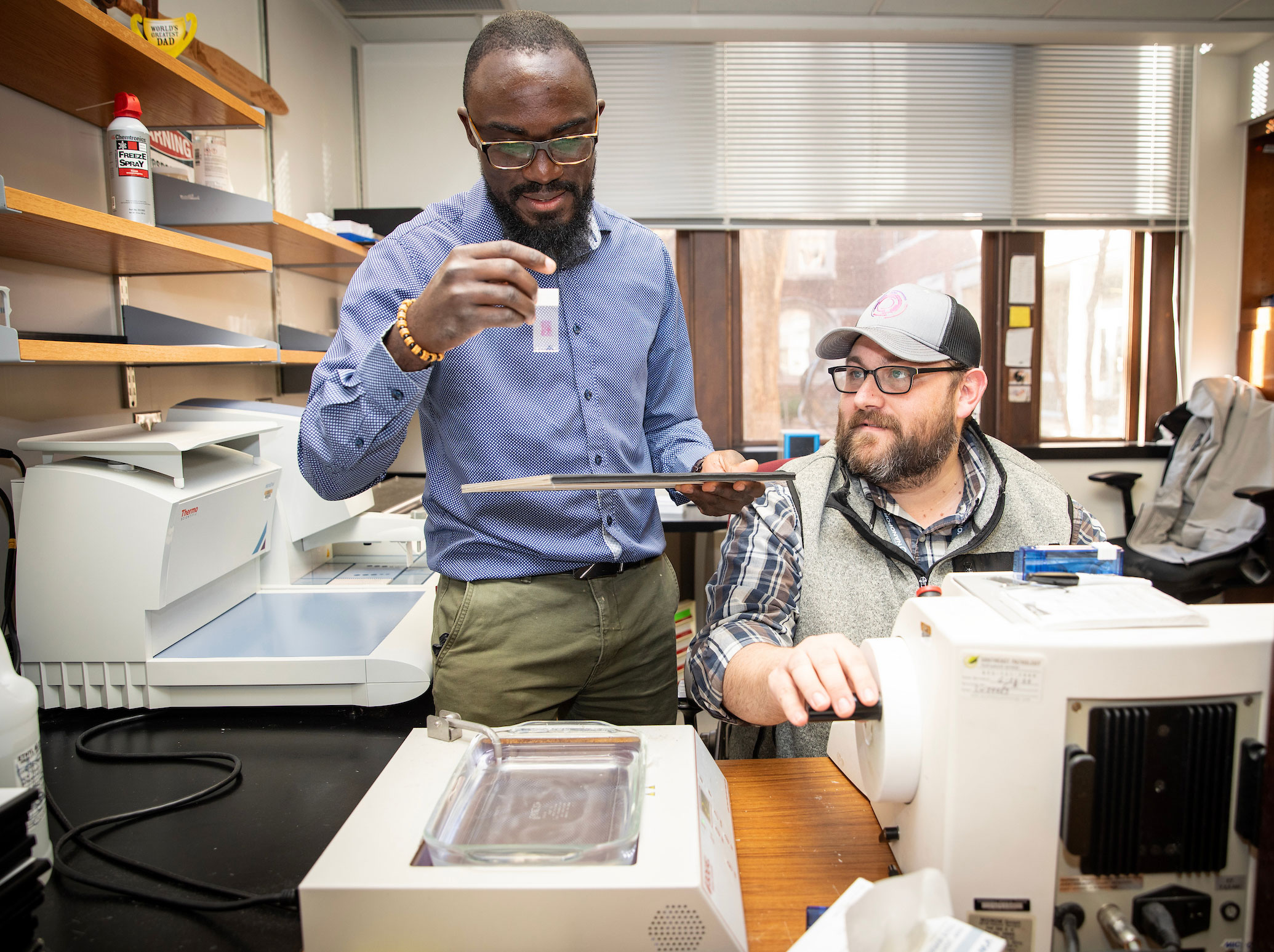 Two young male researchers work together in the lab.