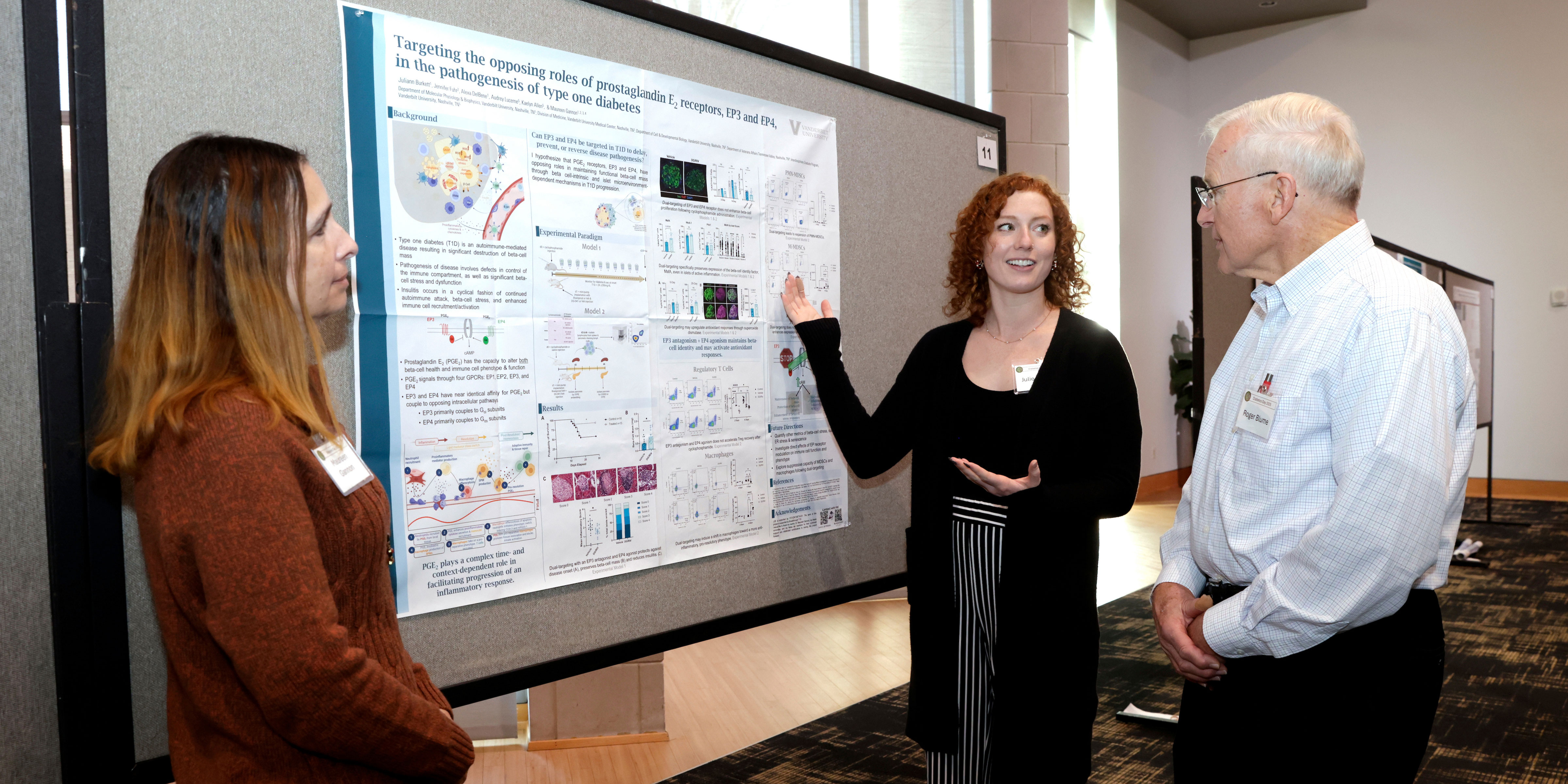A female researcher explains her scientific poster to two people attending a Diabetes Day event.