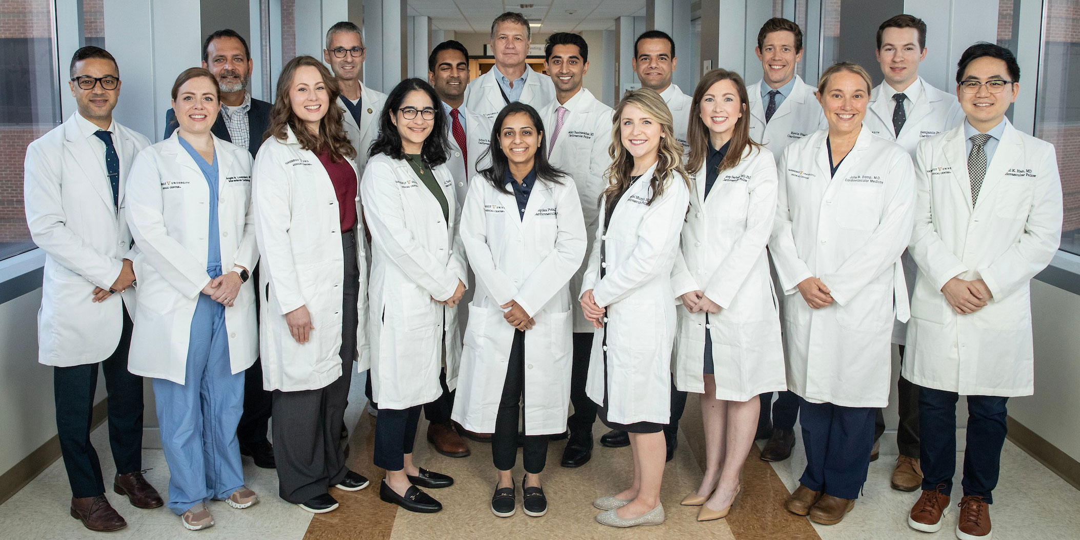 A group of cardiology fellows and faculty mentors pose together on the Vanderbilt hospital sky bridge.