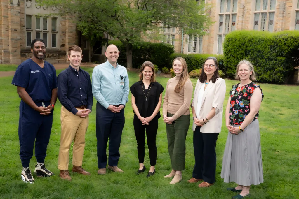 A group of seven Internal Medicine-Pediatrics residents and faculty pose outside.